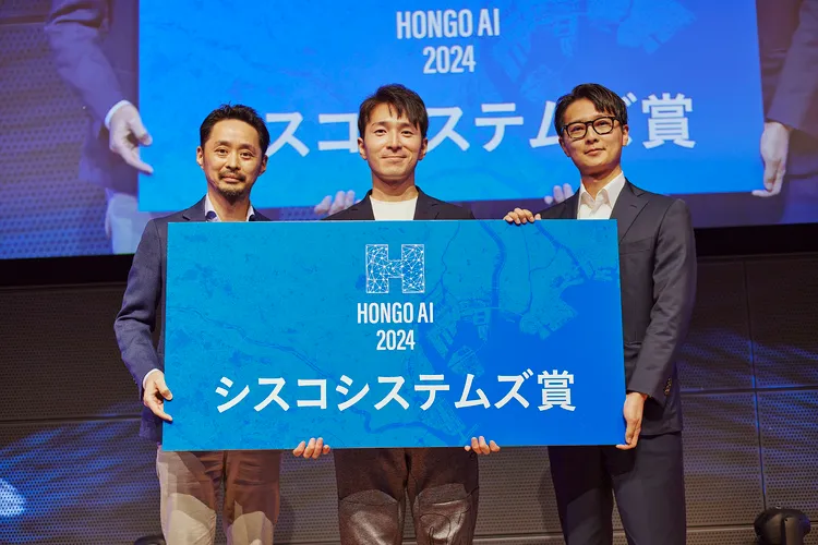 「シスコシステムズ賞」のボードを持つ西山健人CEOと授与者